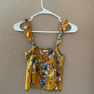 Mustard yellow crop-top w/ flowers throughout.